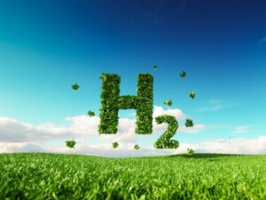 Picture of a green meadow against a blue sky, with the green lettering "H2" for hydrogen.